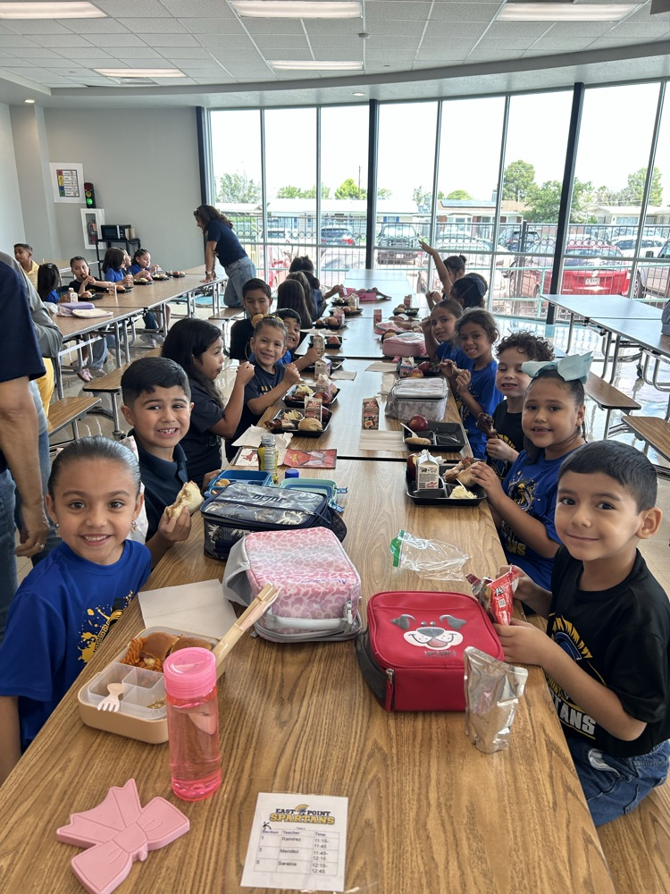 students posing eating lunch in cafeteria 