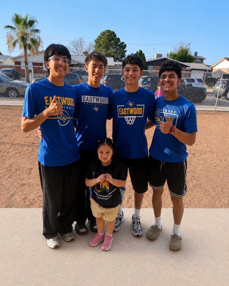 4 Eastwood high school boys’ basketball team members with a kinder student 