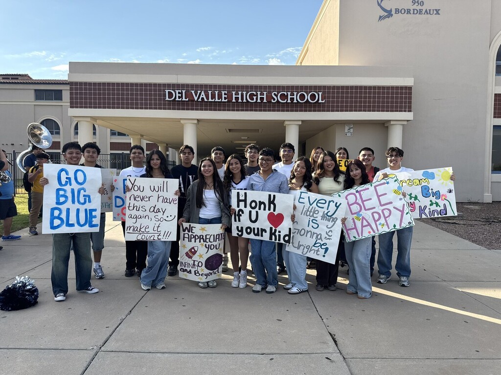 Students holding welcome back to school signs