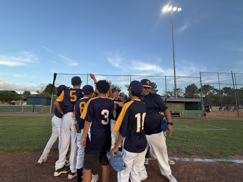 Photo of EKIS baseball team members at a baseball game during a huddle.