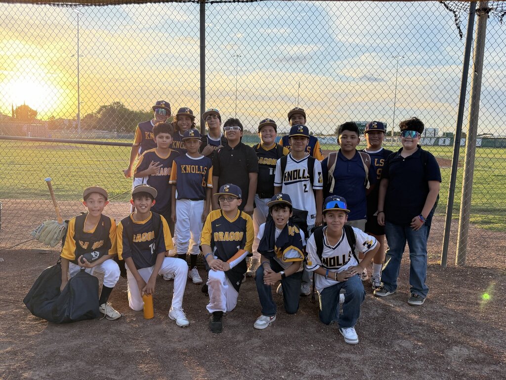 Photo of EKIS baseball team members at a baseball game posing in a group photo.