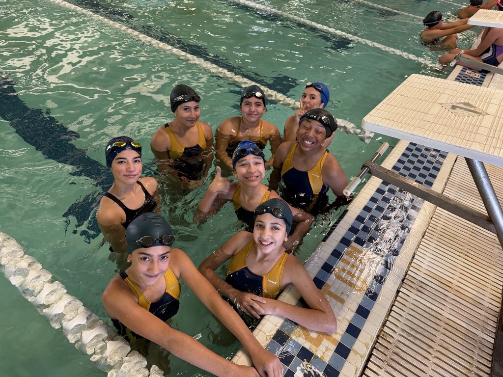 Group photo of some of the EKIS swimming team in the pool.
