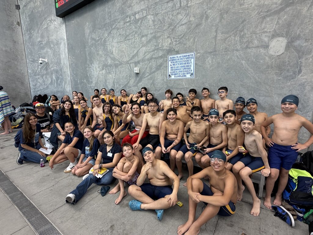 Photo of EKIS Swim team members at the district competition sitting on the bleachers.