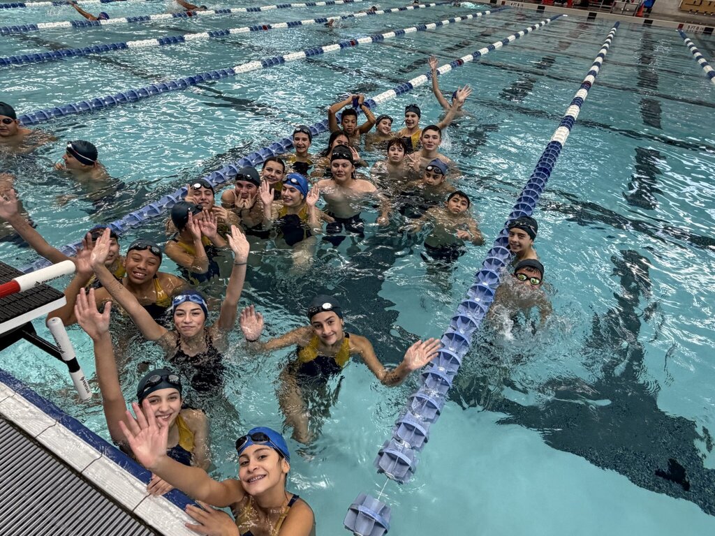 Photo of EKIS Swim team members at the district competition inside the swimming pool.