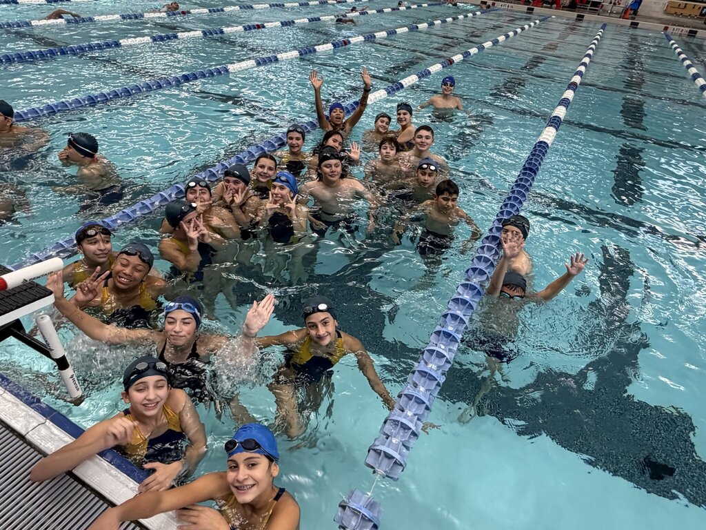 Photo of EKIS Swim team members at the district competition inside the swimming pool.