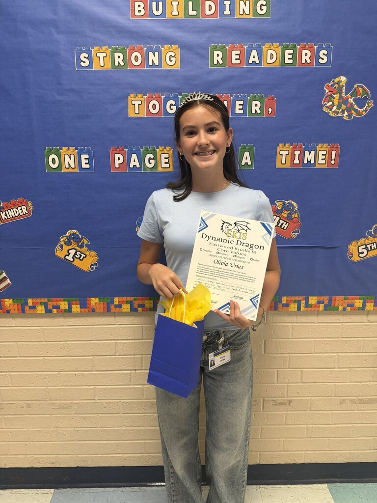Photo of an EKIS student receiving a Dynamic Dragon certificate for their selflessness in upholding EKIS core values.