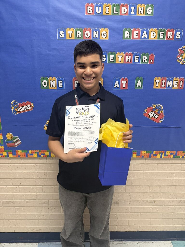 Photo of an EKIS student receiving a Dynamic Dragon certificate for their selflessness in upholding EKIS core values.