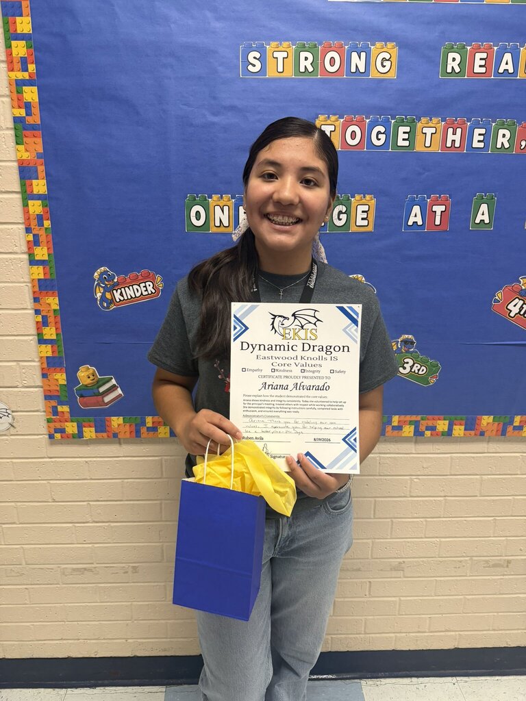 Photo of an EKIS student receiving a Dynamic Dragon certificate for their selflessness in upholding EKIS core values.