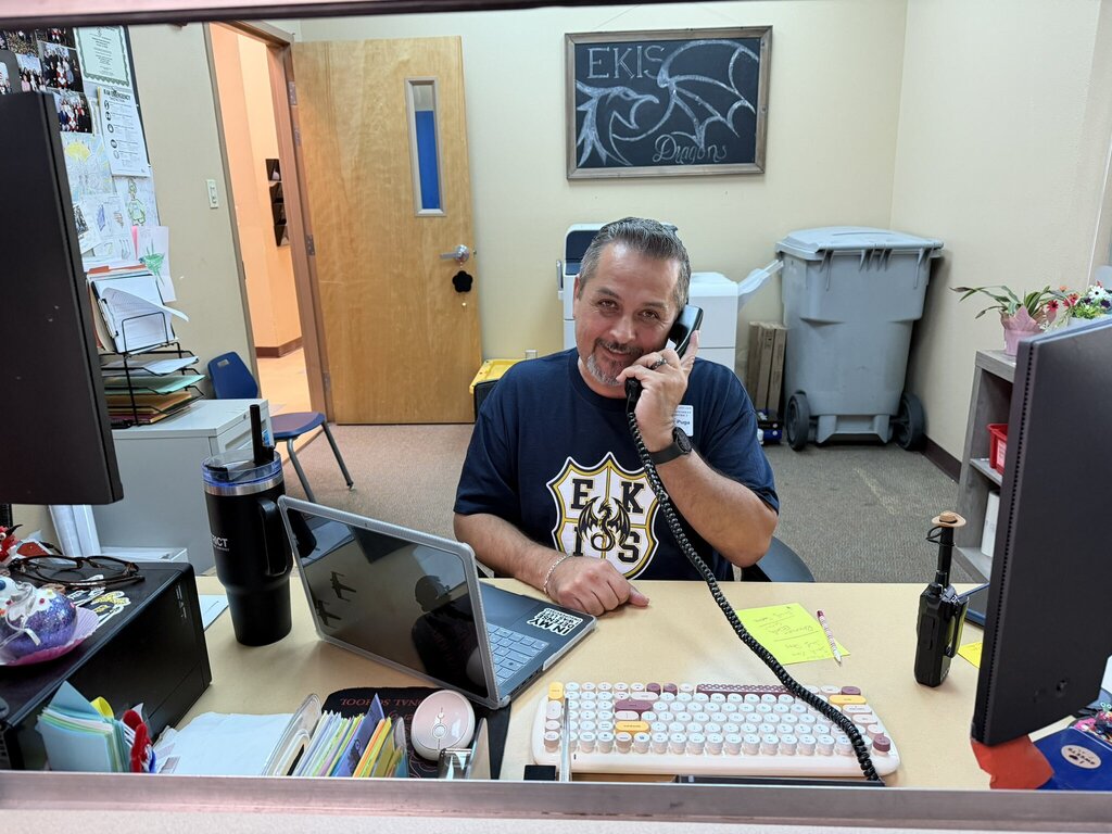 Photo of Mr. Puga helping out by covering the front desk at EKIS.