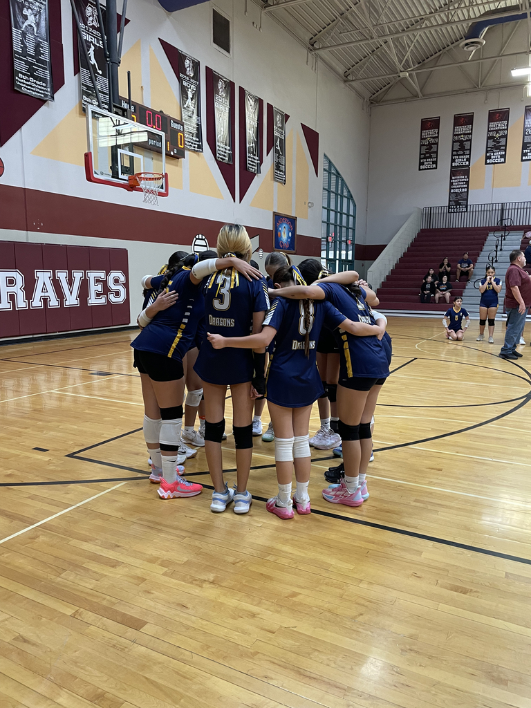 Photo of EKIS 7th-grade volleyball players in a huddle before their match against YMS.