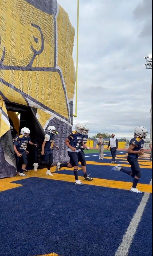 Photo of EKIS 7th and 8th grade football players entering the EHS football field.