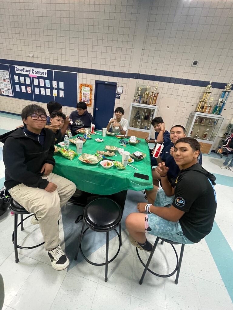 Photo of EKIS football players sitting in groups and eating at a team dinner.