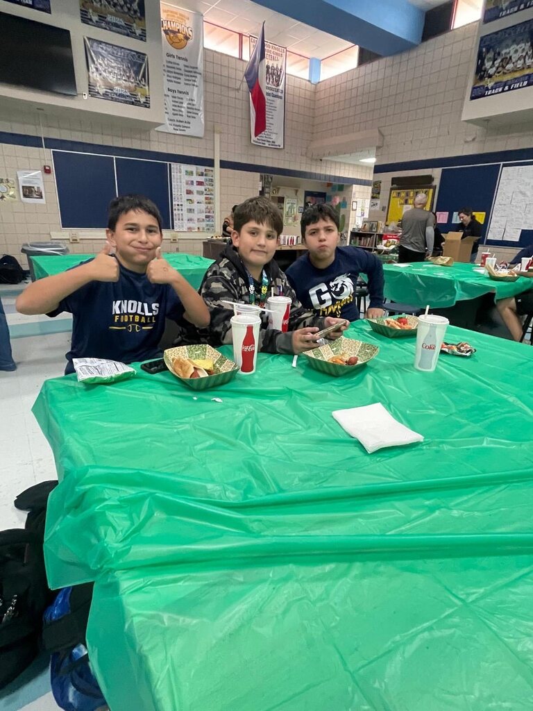 Photo of EKIS football players sitting in groups and eating at a team dinner.