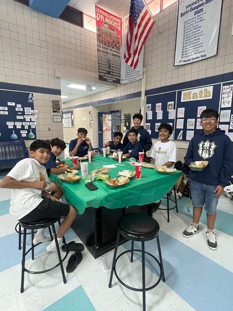 Photo of EKIS football players sitting in groups and eating at a team dinner.
