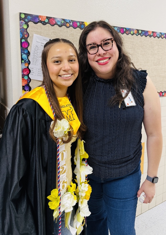 senior posing with former 4th grade teacher, Ms. Amaro