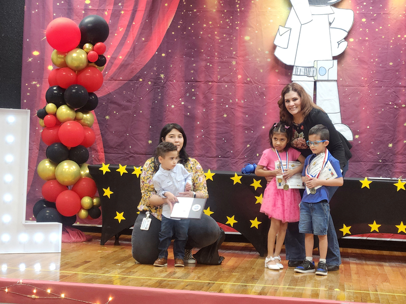 Ms. Esparza and Ms Landini with 3 of their students on stage after receiving their awards