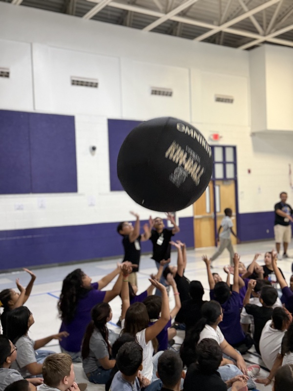 Students reaching up for the  ball. 