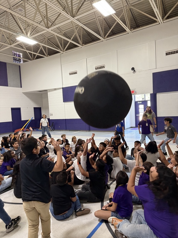 Students reaching up for the  ball. 