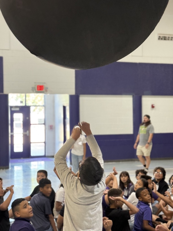Students reaching up for the  ball. 