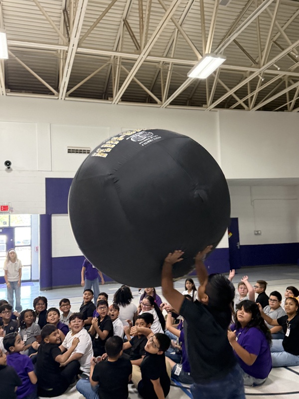 Students reaching up for the  ball. 
