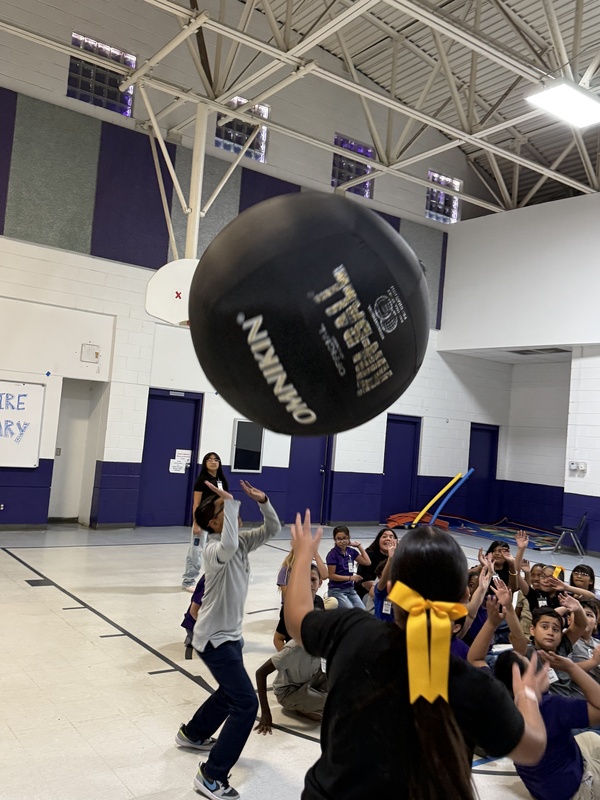 Students reaching up for the  ball. 