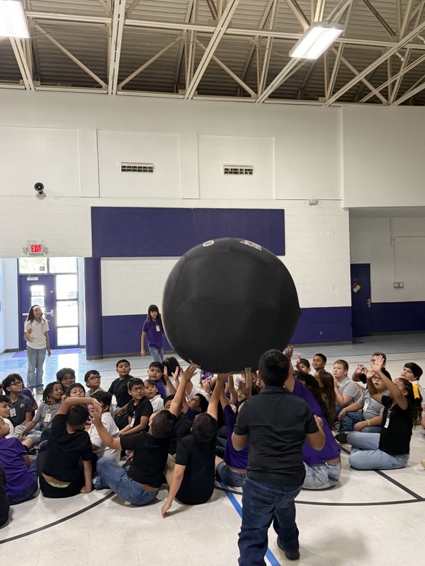 Students reaching up for the  ball. 