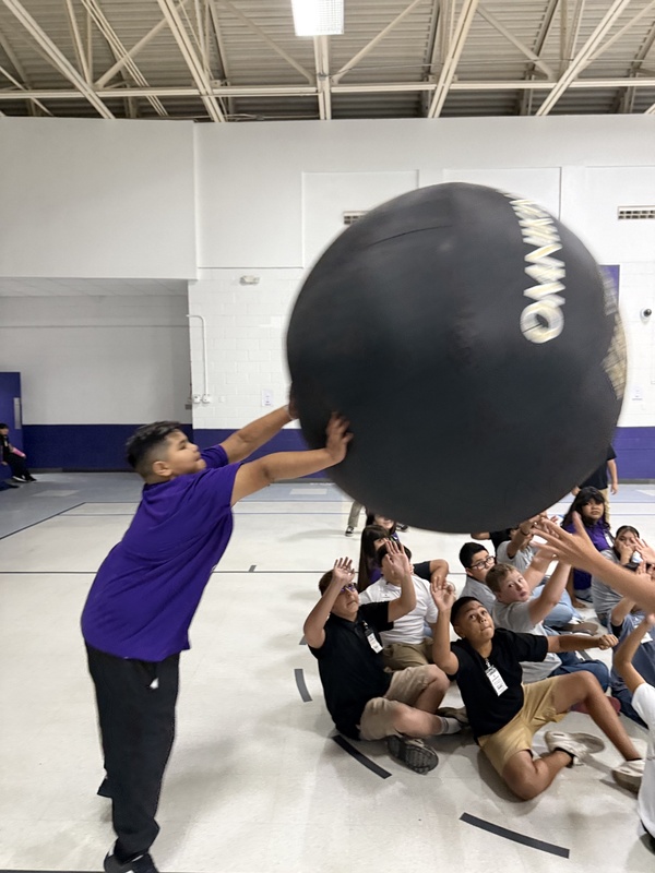 Students reaching up for the  ball. 