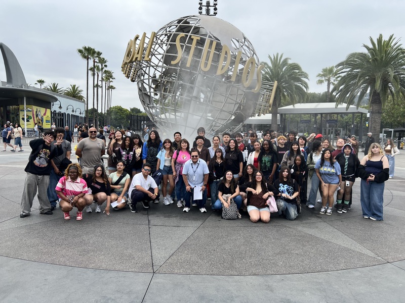 Choir and chaperones pose in front of Universal Studios structure.