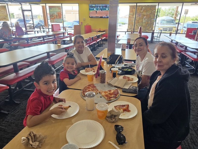 Presa family sits at a table and enjoys pizza