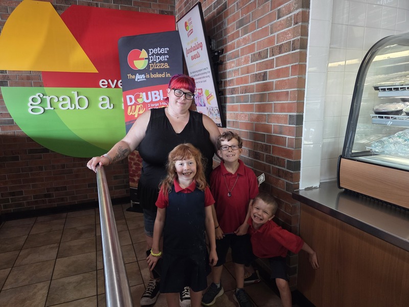 Mom and 3 of her children that attend Presa pose for a photo by the counter before ordering