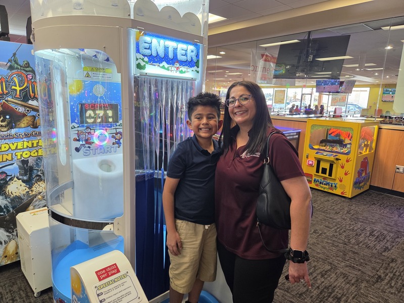 4th grader and his Mom pose for a photo by the game section