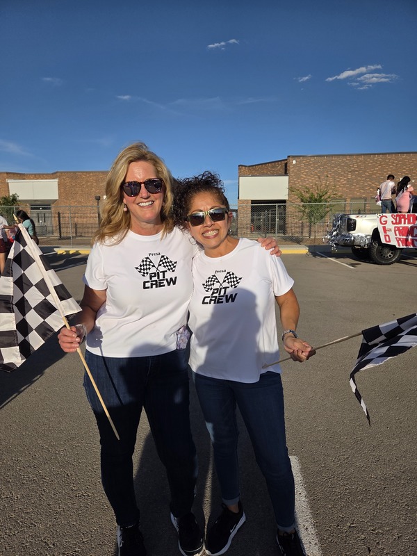 Ms. Banegas and Mrs. Camack at the Homecoming Parade 2025 with checkered flags