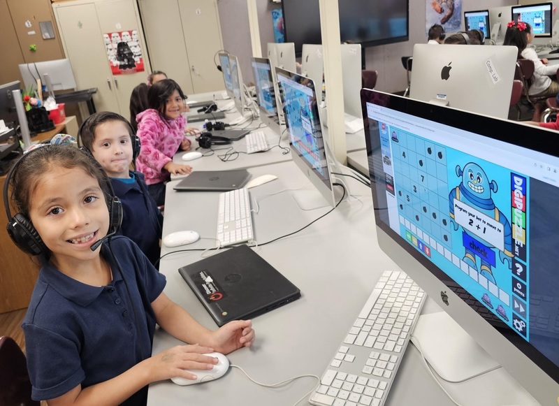 Kinder students practicing math and coding at the same time on desktops