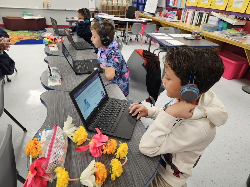 3rd grade boys reading using Amira app at their desks