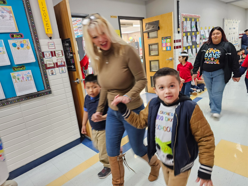 Mrs. Cynor walks with her students in the 100 day parade in the hallway
