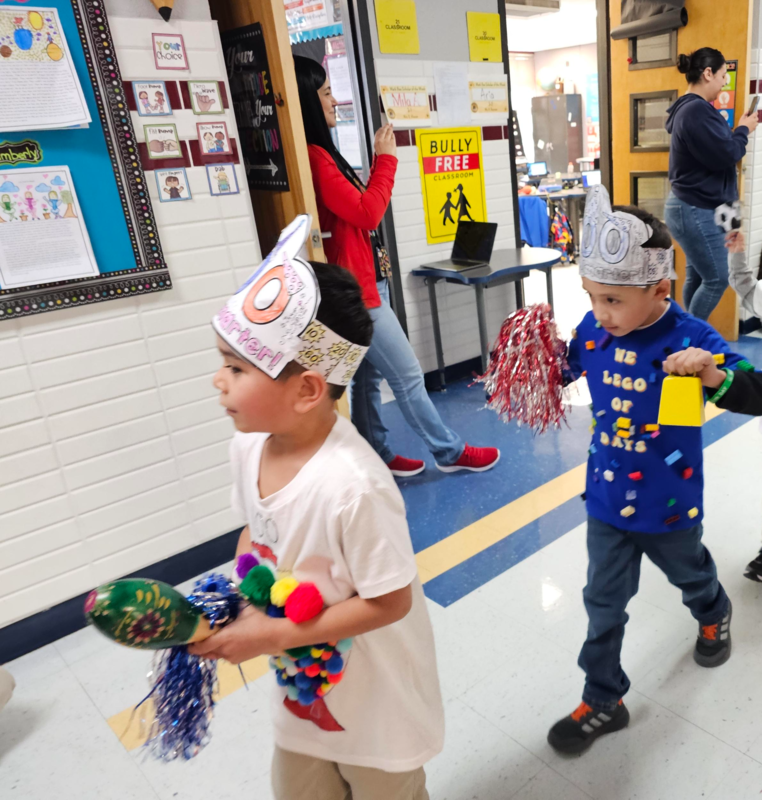 1st graders walk in the 100th day parade down the 3rd grade hall