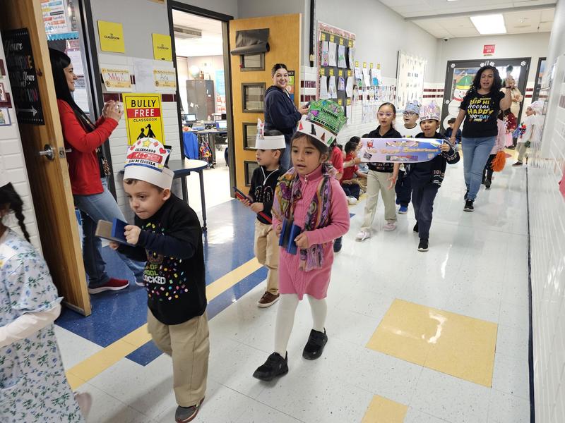 1st graders walk in the 100th day parade down the 3rd grade hall