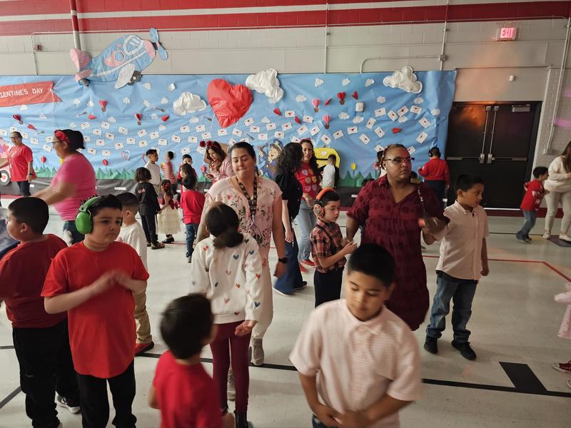 Teachers and students dance in the middle of the dance floor