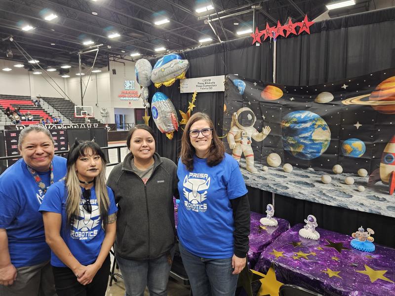 Parents and Coach stand by the tables decorated by the parents