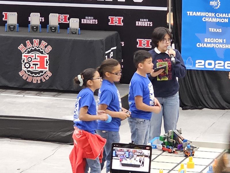 Team B waiting for the timer to begin driving with their robot in front on the table