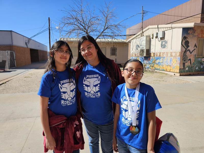 Team B member with her Mom and sister pose for a pic outside by the portables