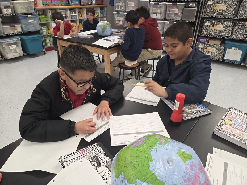 4th grade boys work on recording their data in Science