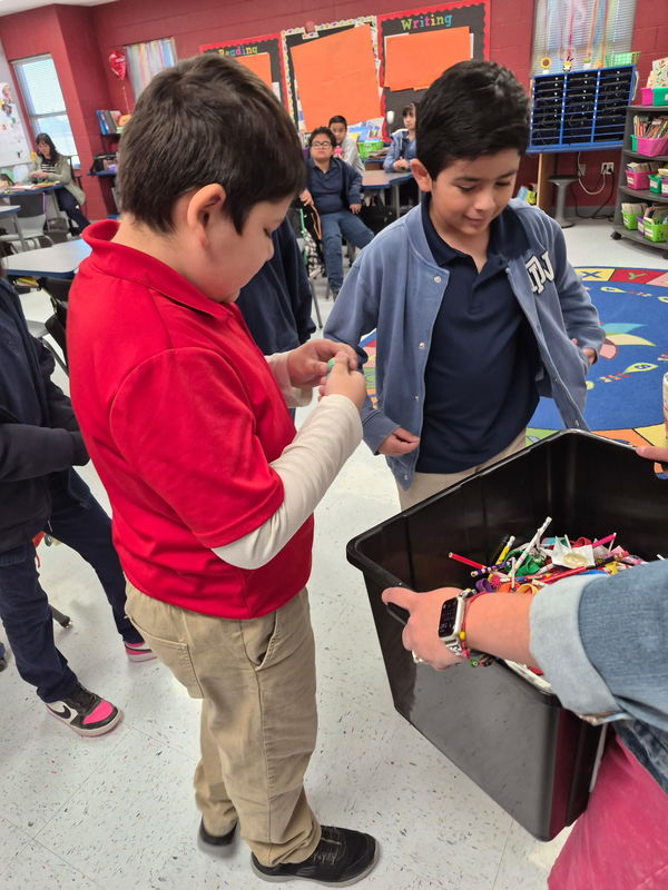 4th graders talk about their prizes in front of the treasure chest