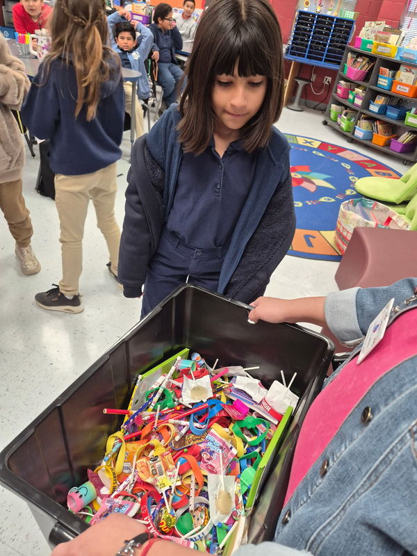 4th grader looking in the treasure chest to choose a prize