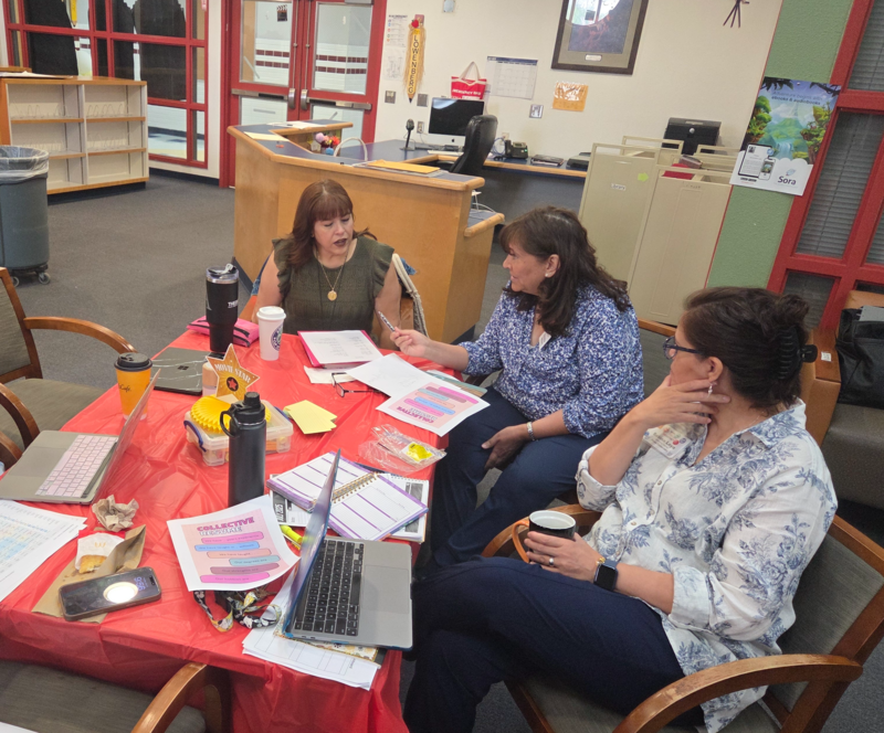 AP Jacquez sitting at a table talking with staff