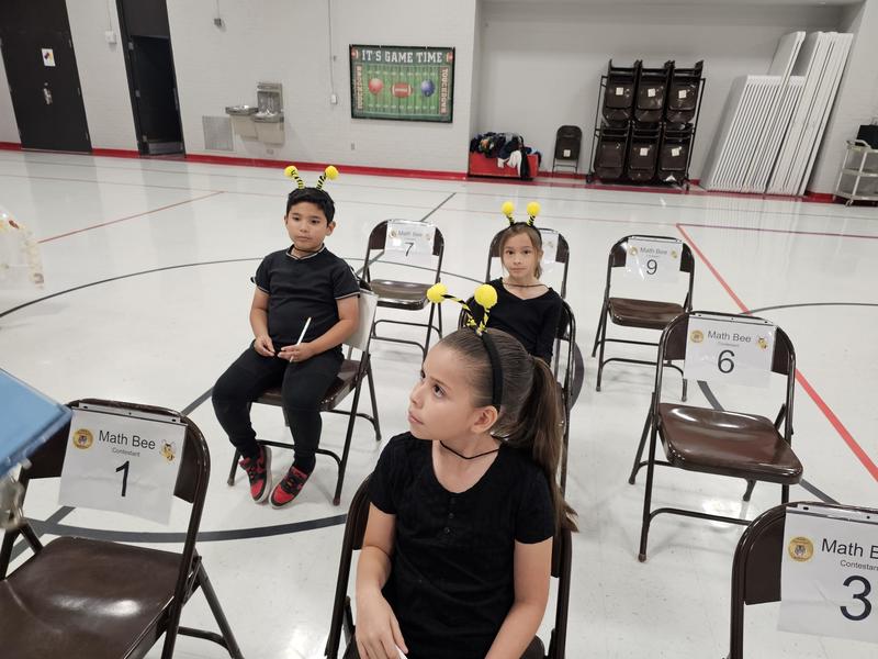 3rd graders in the final awaiting instructions for the  paper test to determine the winners