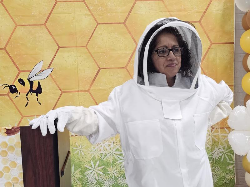 Counselor Mrs. Camack in her Bee Keeper suit waiting by the podium