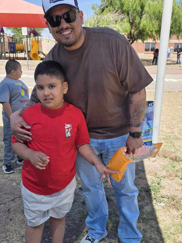Father poses with his son in a red shirt