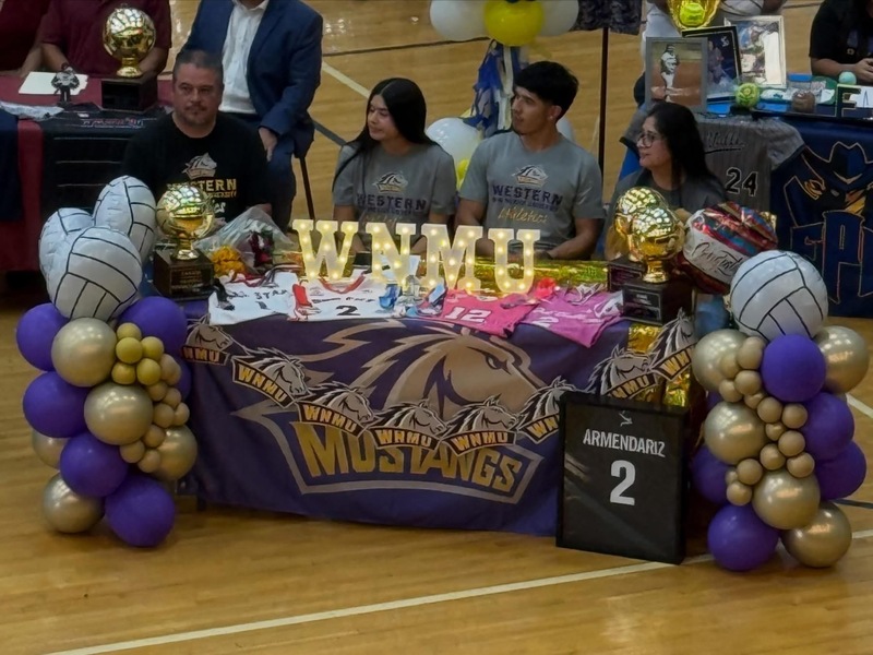 students sitting at tables with family singning letter of intent with colleges