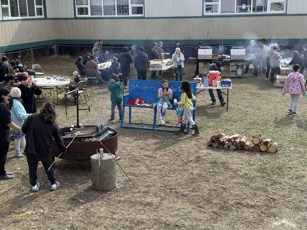 students and adults at a cookout